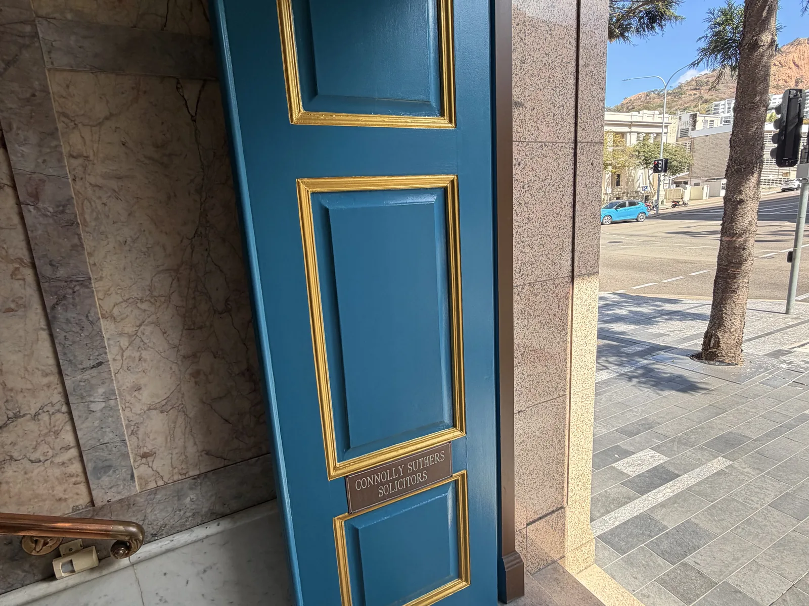 Door repainted in deep teal with gold trim detailing